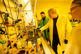 three scientists inspecting some lab metrology equipment